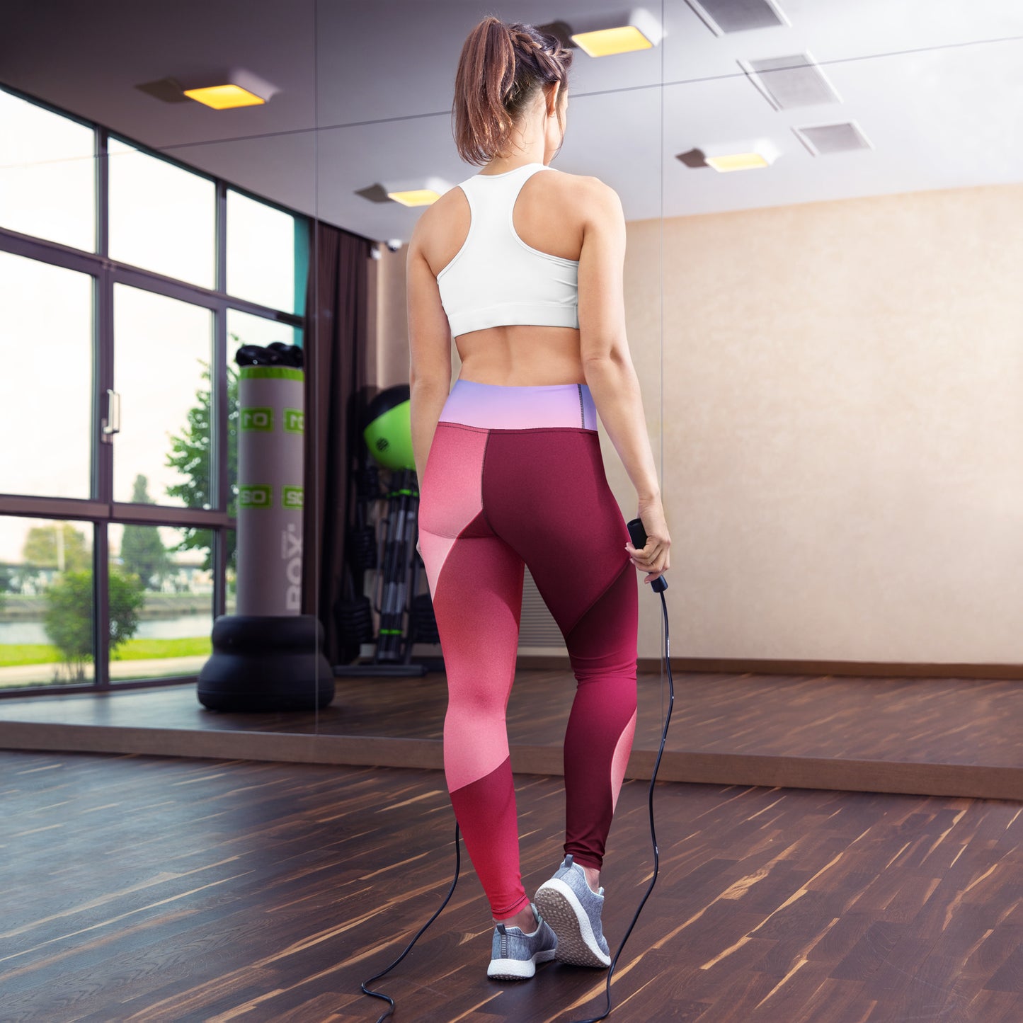 Model poartă colanți yoga cu imprimeu abstract roșu, vedere spate